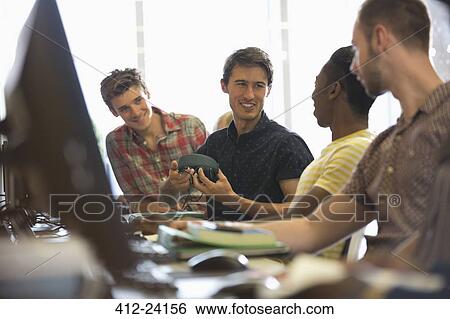 Group of smiling male students sitting at desks with computers and talking View Large Photo Image Stock Photograph - Group of smiling male students sitting at desks with computers and talking. Fotosearch