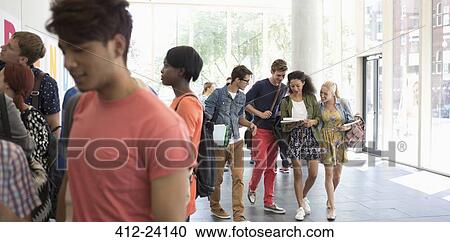 Group of students walking in corridor with books and talking View Large Photo Image Stock Image - Group of students walking in corridor with books and talking. Fotosearch