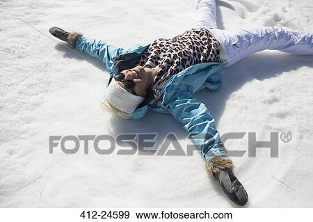 Happy woman making snow angels View Large Photo Image Stock Photo - Happy woman making snow angels. Fotosearch