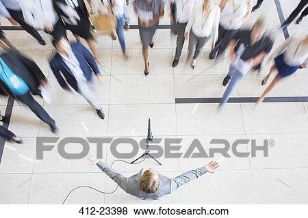 High angle view of business people walking towards colleague giving speech View Large Photo Image Stock Photo - High angle view of business people walking towards colleague giving speech. Fotosearch