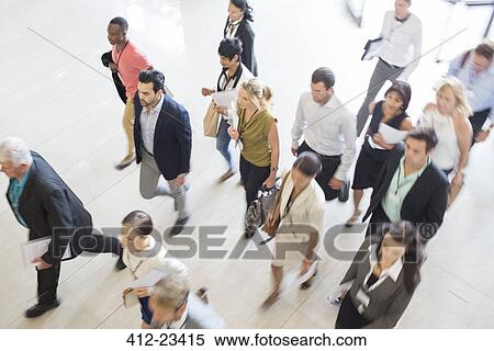 Stock Photography - High angle view of business people walking in office. Fotosearch