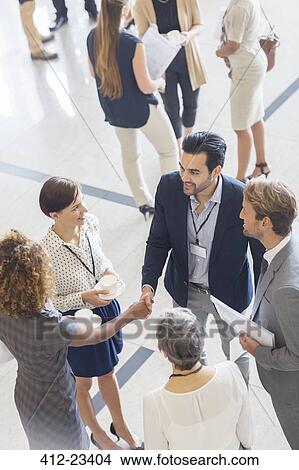 High angle view of group of business people shaking hands in office View Large Photo Image Picture - High angle view of group of business people shaking hands in office. Fotosearch