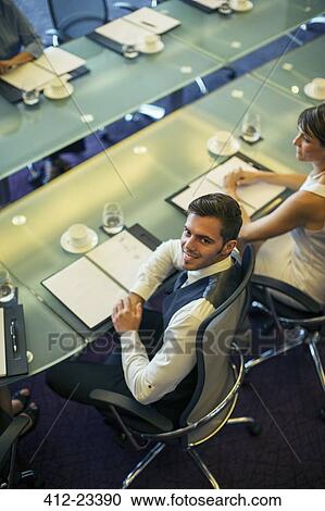 High angle view of young businessman sitting at conference table View Large Photo Image Stock Image - High angle view of young businessman sitting at conference table. Fotosearch