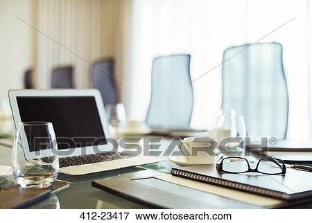 Laptop, eyeglasses and diary on conference table in empty conference room View Large Photo Image Stock Photo - Laptop, eyeglasses and diary on conference table in empty conference room. Fotosearch