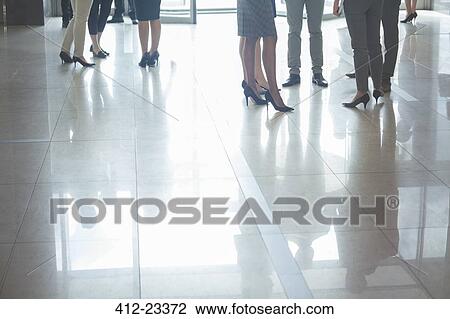 Low section of business people standing in hall, with reflections on tiled floor View Large Photo Image Stock Image - Low section of business people standing in hall, with reflections on tiled floor. Fotosearch