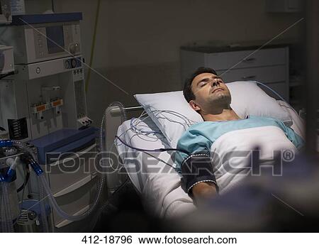 Male patient lying in hospital bed in intensive care unit View Large Photo Image Stock Photograph - Male patient lying in hospital bed in intensive care unit . Fotosearch