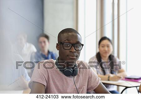 Male student with eyeglasses and headphones around neck looking at camera during lecture View Large Photo Image Stock Image - Male student with eyeglasses and headphones around neck looking at camera during lecture. Fotosearch