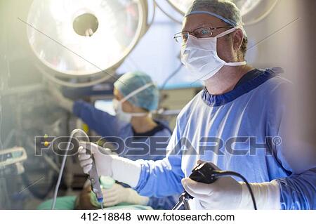 Male surgeon holding laparoscopy equipment during surgery in operating theater View Large Photo Image Stock Photo - Male surgeon holding laparoscopy equipment during surgery in operating theater. Fotosearch