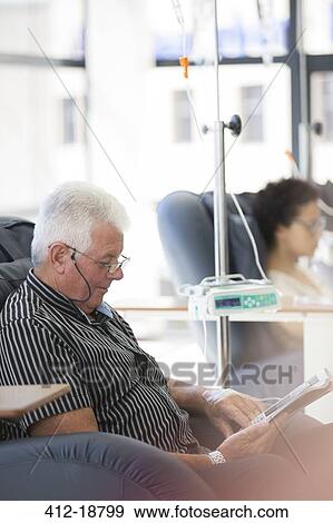 Man reading magazine, undergoing medical treatment in outpatient clinic View Large Photo Image Stock Photo - Man reading magazine, undergoing medical treatment in outpatient clinic. Fotosearch