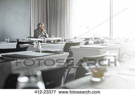 Mature businessman sitting in office restaurant with hands clasped View Large Photo Image Stock Photo - Mature businessman sitting in office restaurant with hands clasped. Fotosearch