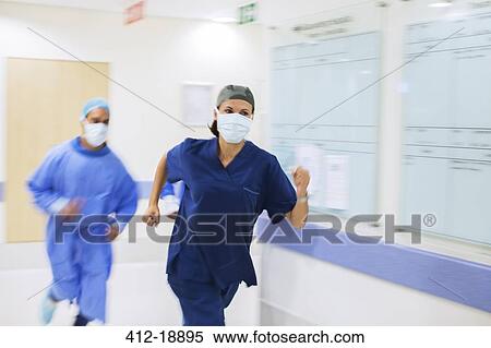 Medical staff wearing scrubs and surgical masks rushing down hospital corridor View Large Photo Image Stock Photography - Medical staff wearing scrubs and surgical masks rushing down hospital corridor. Fotosearch