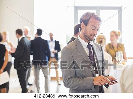 Mid adult businessman text messaging in office View Large Photo Image Stock Photography - Mid adult businessman text messaging in office. Fotosearch