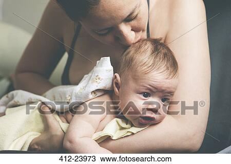 Mother holding and kissing baby wrapped in cloth after bath View Large Photo Image Stock Image - Mother holding and kissing baby wrapped in cloth after bath. Fotosearch
