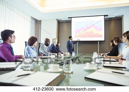 Stock Image - Multiethnic group of people listening to presentation in conference room. Fotosearch