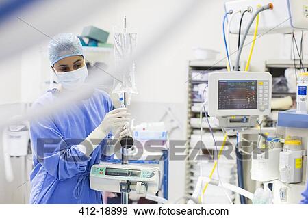 Stock Photo - Nurse standing by medical and monitoring equipment. Fotosearch