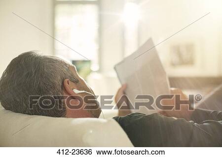 Older man listening to headphones on sofa View Large Photo Image Stock Photograph - Older man listening to headphones on sofa. Fotosearch