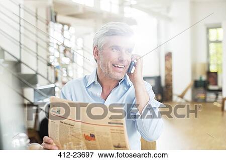 Older man talking on cell phone with newspaper View Large Photo Image Stock Photo - Older man talking on cell phone with newspaper. Fotosearch