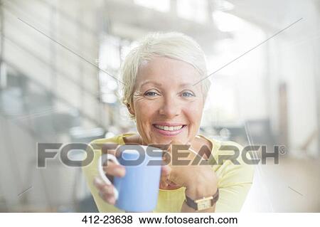 Stock Photo - Older woman drinking cup of coffee. Fotosearch