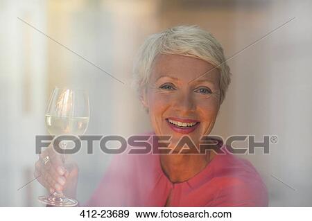 Older woman drinking glass of white wine View Large Photo Image Stock Photo - Older woman drinking glass of white wine. Fotosearch