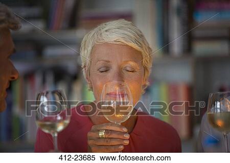 Stock Photography - Older woman smelling white wine. Fotosearch