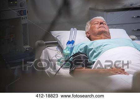 Patient lying in bed next to oxygen mask in intensive care unit View Large Photo Image Stock Image - Patient lying in bed next to oxygen mask in intensive care unit. Fotosearch