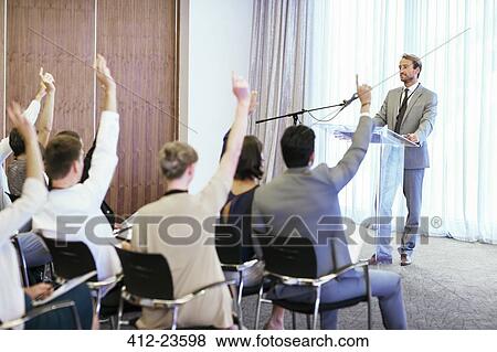 Stock Photo - People at seminar raising hands to ask questions. Fotosearch