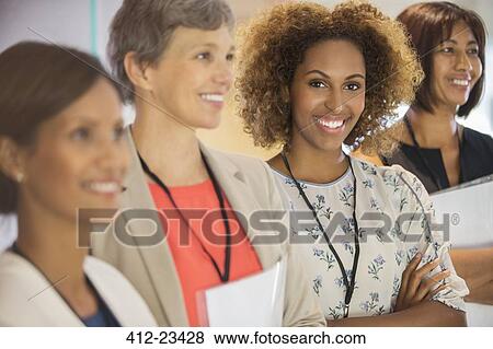 Portrait of businesswoman, looking at camera and standing with her colleagues View Large Photo Image Stock Photo - Portrait of businesswoman, looking at camera and standing with her colleagues. Fotosearch