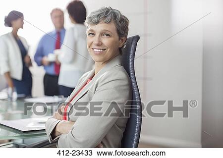 Portrait of businesswoman sitting in chair with arms crossed in conference room View Large Photo Image Stock Image - Portrait of businesswoman sitting in chair with arms crossed in conference room. Fotosearch