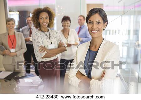 Portrait of confident businesswoman, with colleagues in background in conference room View Large Photo Image Stock Image - Portrait of confident businesswoman, with colleagues in background in conference room. Fotosearch