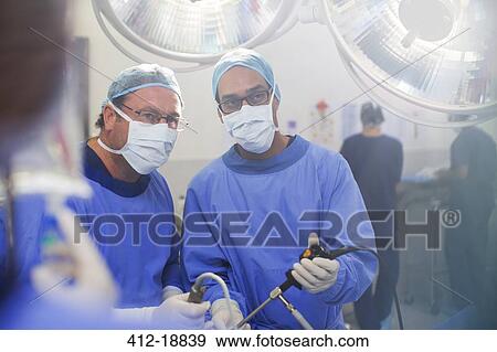 Portrait of doctors performing laparoscopic surgery in operating theater View Large Photo Image Stock Photo - Portrait of doctors performing laparoscopic surgery in operating theater. Fotosearch