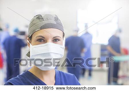 Stock Photography - Portrait of female doctor wearing surgical cap and mask in operating theater. Fotosearch