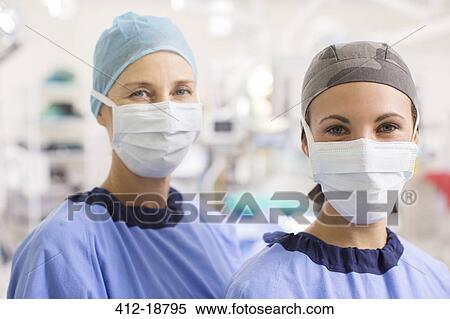 Stock Photography - Portrait of female doctors wearing scrubs in operating theater. Fotosearch