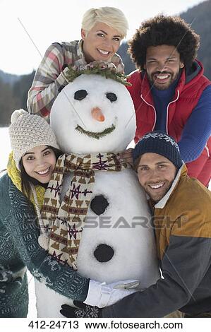 Portrait of friends with snowman View Large Photo Image Stock Image - Portrait of friends with snowman. Fotosearch