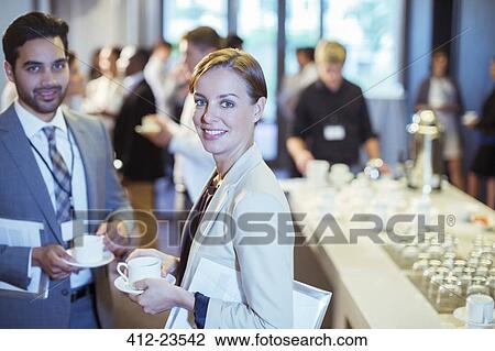 Portrait of man and woman standing in lobby of conference center during coffee break View Large Photo Image Stock Image - Portrait of man and woman standing in lobby of conference center during coffee break. Fotosearch