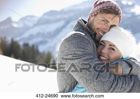 Portrait of smiling couple hugging in snow View Large Photo Image Stock Image - Portrait of smiling couple hugging in snow. Fotosearch