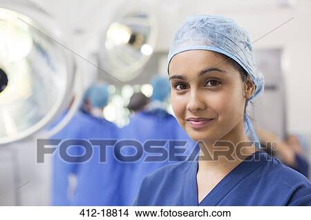 Portrait of smiling female surgical nurse wearing blue surgical cap and scrubs View Large Photo Image Picture - Portrait of smiling female surgical nurse wearing blue surgical cap and scrubs. Fotosearch
