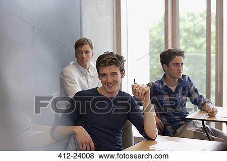 Portrait of smiling university student sitting at desk View Large Photo Image Stock Photo - Portrait of smiling university student sitting at desk. Fotosearch