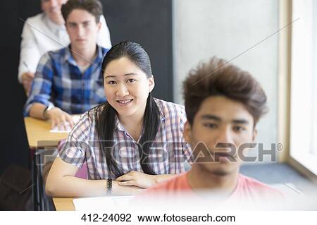 Portrait of smiling university students sitting in classroom View Large Photo Image Stock Image - Portrait of smiling university students sitting in classroom. Fotosearch