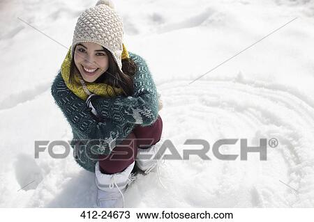 Stock Image - Portrait of smiling woman in snow. Fotosearch