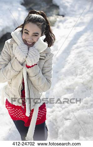 Stock Image - Portrait of smiling woman in snow. Fotosearch