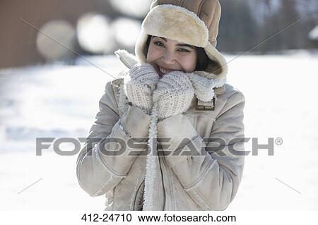 Stock Image - Portrait of smiling woman in snow. Fotosearch