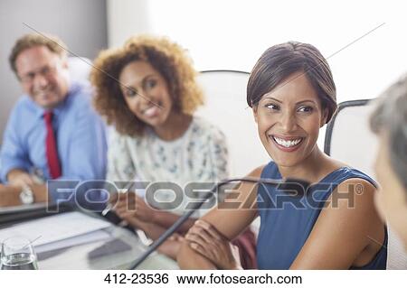 Portrait of smiling woman sitting at conference table View Large Photo Image Stock Photograph - Portrait of smiling woman sitting at conference table. Fotosearch