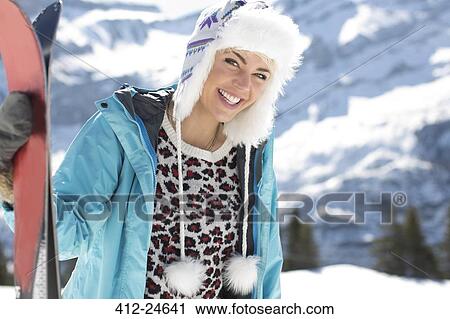 Stock Image - Portrait of smiling woman with skis. Fotosearch
