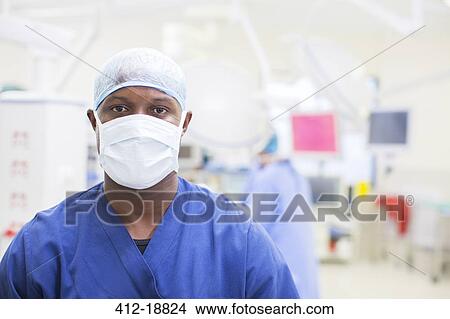 Picture - Portrait of surgeon wearing surgical mask and cap in operating theater. Fotosearch