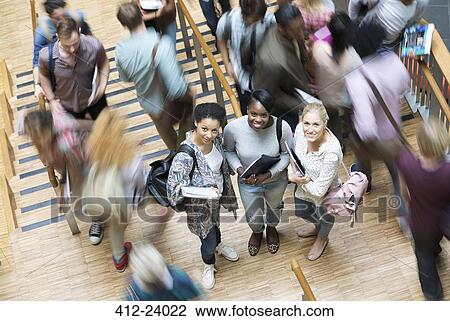 Portrait of three university students at university, other students walking down stairs View Large Photo Image Stock Image - Portrait of three university students at university, other students walking down stairs. Fotosearch