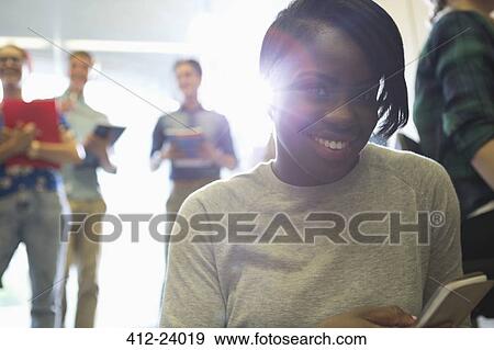 Stock Photo - Portrait of university student texting in corridor. Fotosearch
