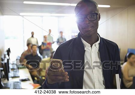 Stock Photo - Portrait of university student with smartphone in classroom. Fotosearch