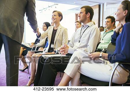 Stock Photography - Public speaker shaking hands with people attending seminar. Fotosearch