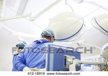 Rear view of doctor wearing surgical cap, mask and gown in operating theater View Large Photo Image Stock Photo - Rear view of doctor wearing surgical cap, mask and gown in operating theater. Fotosearch