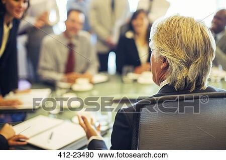 Stock Image - Rear view of mature businessman during business meeting. Fotosearch